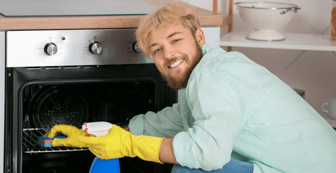 young man cleaning oven kitchen 1