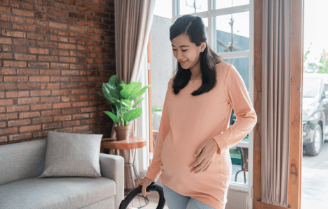 pregnant woman cleaning floor with vacuum cleaner 1